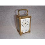 A BRASS CASED CARRIAGE CLOCK, with bevelled glass panels, 6" high including swing handle