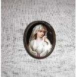 A HAND PAINTED PORTRAIT BROOCH of a lady's head and shoulders, in an oval frame