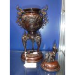 A JAPANESE PATINATED BRONZE CENSER AND COVER on a tripod base with raised bird and flower