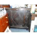 A DARK OAK CUPBOARD, with carved decoration, fitted a single door 47" high x 48" wide