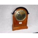 AN EDWARDIAN OAK-CASED MANTEL CLOCK with polished brass dial, 12.5" high