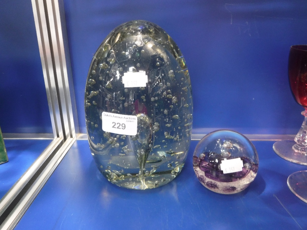 A LARGE AND HEAVY VICTORIAN GLASS DUMPY WEIGHT with bubble inclusions, 7.5" high and one other