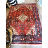 A RED GROUND PERSIAN RUG, 52" x 77"