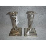 A PAIR OF SILVER CANDLESTICKS, the reeded column above a stepped base, 6" high