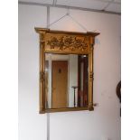 A REGENCY GILT FRAMED PIER GLASS, with flank columns and central panel decorated with a rose