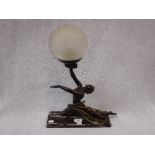 A REPRODUCTION ART DECO TABLE LAMP in the form of a dancer, her hand supporting a crackle frosted