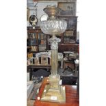 A VICTORIAN BRASS CORINTHIAN COLUMN OIL LAMP with cut glass reservoir 23.25" high (including