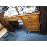 AN EDWARDIAN LIGHT OAK DESK with inset green leather top 29" high x 39" wide