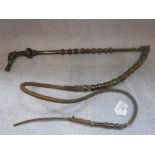 A CAMEL RIDING CROP with stylised animal head and silvered metal mounts