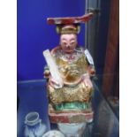 A PAINTED CARVED WOODEN FRAGMENT OF A DEITY seated on a throne