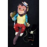 A VINTAGE 1950S/60S JAPANESE BATTERY OPERATED TIN PLATE MONKEY with plastic covered paws and face,