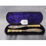 A PAIR OF IVORY HANDLED SILVER BLADED BUTTER KNIVES in leather presentation case