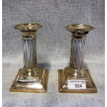 A PAIR OF SILVER CORINTHIAN COLUMN CANDLESTICKS with detachable sconces and loaded bases