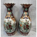 A LARGE PAIR OF ORIENTAL VASES decorated with figures within a garden, 21" high