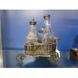 A PLATED THREE BOTTLE CHARIOT FORM TABLE CRUET