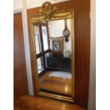 A NEO-CLASSICAL STYLE GILT FRAMED WALL MIRROR, 23" wide x 51" high