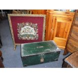 A GREEN PAINTED PINE CHEST with metal mounts and a gilt framed needlework fire screen