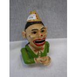 A PAINTED ALUMINIUM MONEY BOX in the form of a clown, 7.5" high