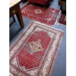 A RED GROUND PERSIAN RUG, 42" X 60" and another 44" x 62"