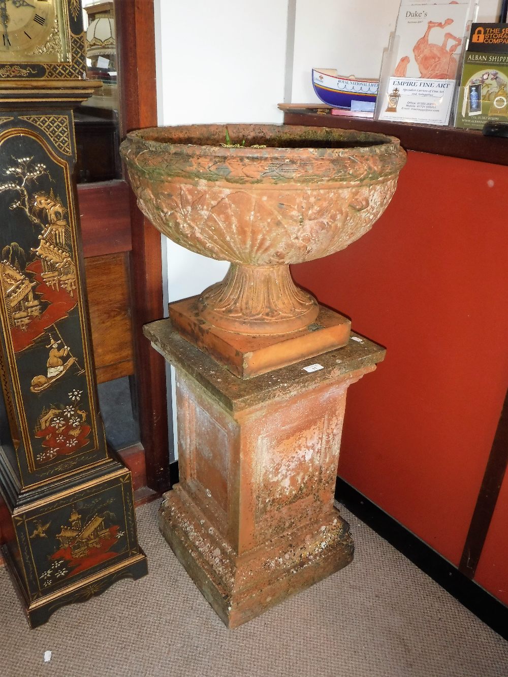 AN EARLY 20TH CENTURY TERRACOTTA GARDEN URN, resting on a square plinth