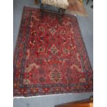A RED GROUND PERSIAN RUG, 56" X 80"