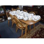 ERCOL: AN ELM DINING TABLE with beech legs, 59" long x 28" wide and a set of six stick-back chairs