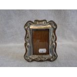 A SILVER EASEL PHOTOGRAPH FRAME with light oak back 5.5" high