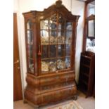 A REPRODUCTION DUTCH WALNUT DISPLAY CABINET of bombe form, 51" wide