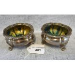 A PAIR OF VICTORIAN SILVER SALTS of bulbous form, raised on acanthus leaf scrolled feet by Robert
