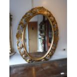 AN OVAL WALL MIRROR in a gilt frame, 38" high x 28.5" wide