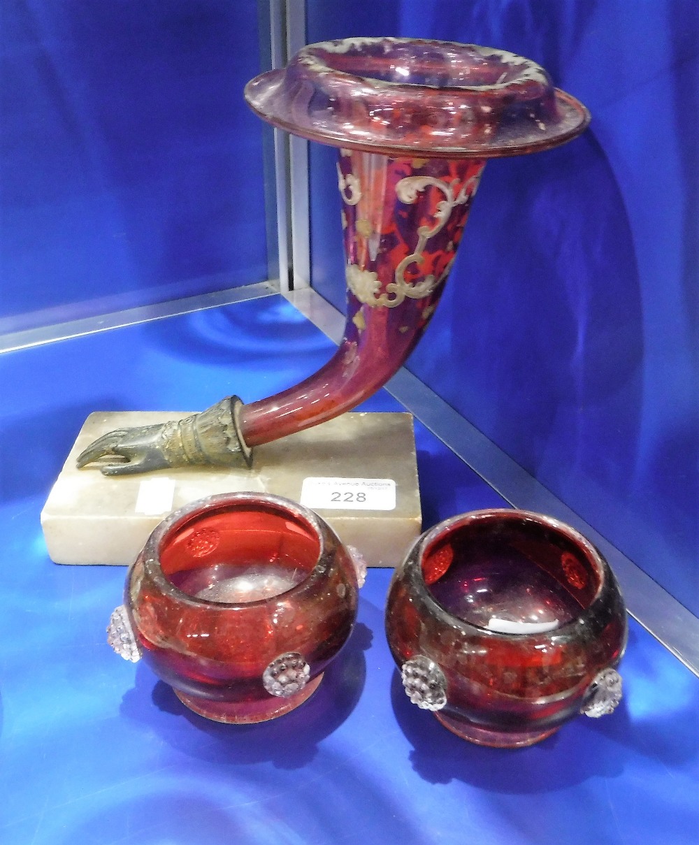 A VICTORIAN CRANBERRY GLASS VASE, mounted on a brass hand and platform base and two similar vases