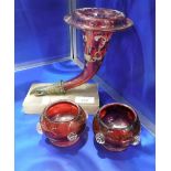 A VICTORIAN CRANBERRY GLASS VASE, mounted on a brass hand and platform base and two similar vases