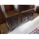 A 17TH CENTURY OAK COFFER, with carved three panelled front, 22" high x 45" wide