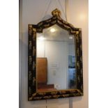 A GOTHIC STYLE ARCHED WALL MIRROR in a black and gilt frame, decorated with birds, 26" high x 16"