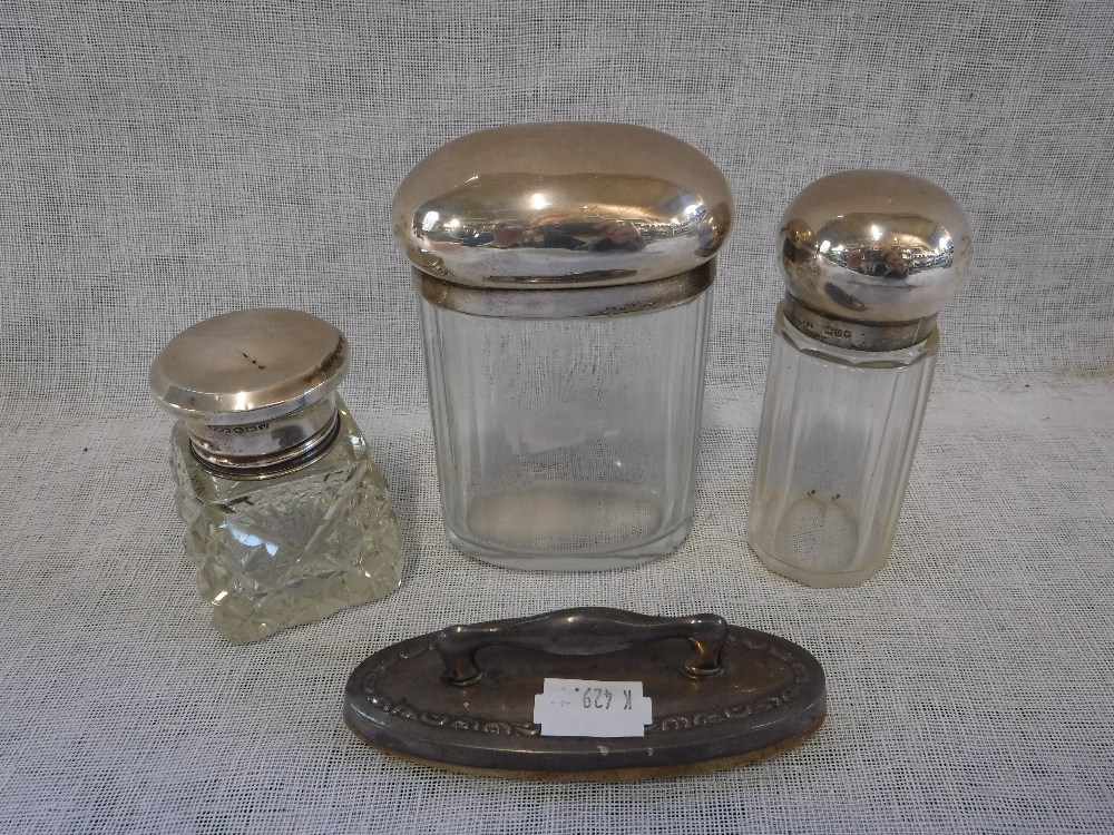 THREE SILVER MOUNTED CUT-GLASS BOTTLES and a silver nail buffer (4)