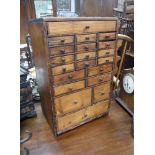 AN EARLY 20TH CENTURY PINE WATCHMAKER'S CHEST, containing many small drawers, 20" high x 12.5" wide