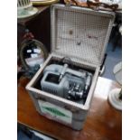 A VINTAGE 'FILMO' PROJECTOR in a period case, with interesting travelling labels including '