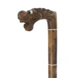 Oriental hardwood segmented walking stick with carved handle in the form of a dragons head, 90cm