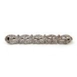 Good quality diamond bar brooch, set with five centred stones surrounded by seventy smaller