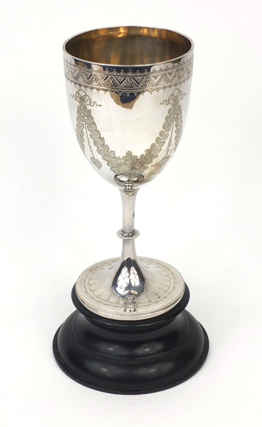 Large silver goblet with engraved floral swag decoration, R.P London 1906, raised on an ebonised