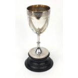 Large silver goblet with engraved floral swag decoration, R.P London 1906, raised on an ebonised