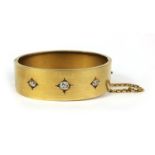 Unmarked gold bangle set with three diamonds, approximately 6.2cm x 5.5cm, approximate weight 30.