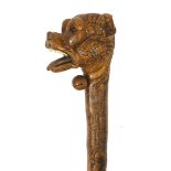 Naturalistic wooden walking stick with carved pommel in the form of a dogs head, with ivory teeth