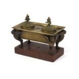 Continental bronze twin inkwell with giffin supports, raised on a red marble base, 15cm high x