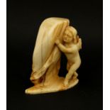 Ivory carving of a Putti hiding behind a curtain, 7.2cm high