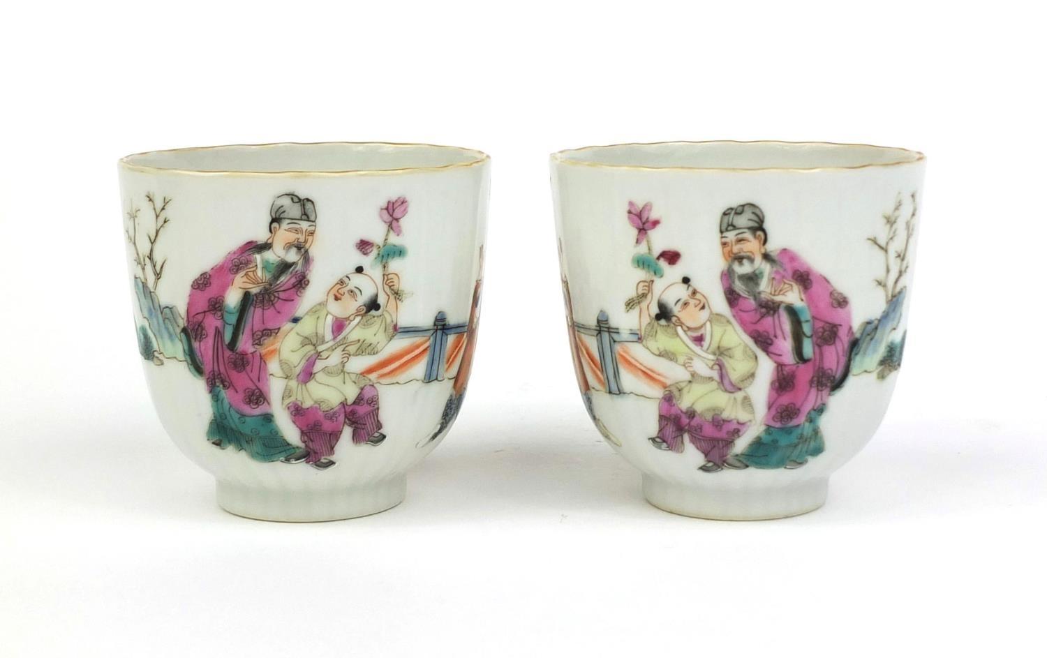 Pair of Chinese porcelain tea cups, hand painted in the famille rose palette with court figures