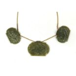 Three Islamic green nephrite panels on a gold coloured metal necklace, the panels carved with