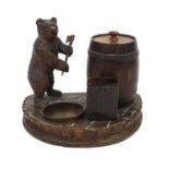 Carved Black Forest smokers desk stand, mounted with a bear and barrel tobacco box, 17cm high