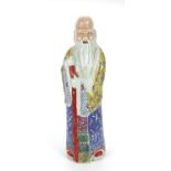 Chinese porcelain figure of an elder holding a staff, wearing a robe hand painted with fruit,