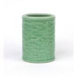 Chinese celadon glazed cylindrical brush pot, decorated in low relief with a continuous band of